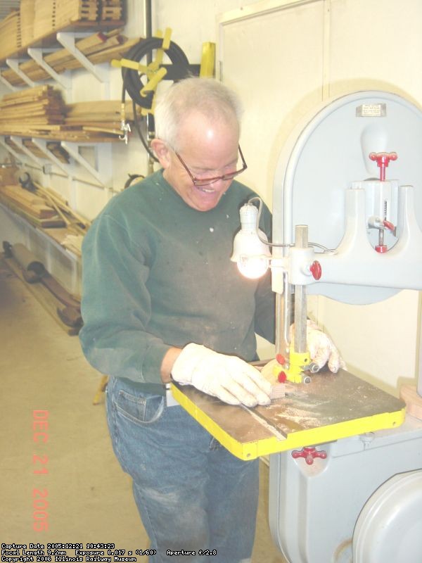 12.21.05 - DICK CUBBAGE IS ROUGH CUTTING MORE PARTS FOR THE WHEEL ON THE BANDSAW.