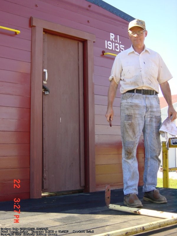 09.22.07 - VICTOR STANDS IN FRONT OF THE DOOR WHICH HAD NEW TRIM MILLED AND APPLIED BY KIRK WARNER.  THE REMAINING DECK BOARDS WERE STAINED AND MORE OF THE INTERIOR WALLS WERE SANDED.  THE CAR NUMBER HAS BEEN OUTLINED TO PAINT ON THE RIGHT SIDE OF THE CAR.