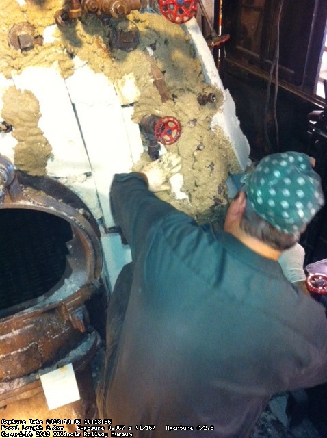 Collin applies insulating mud to the backhead