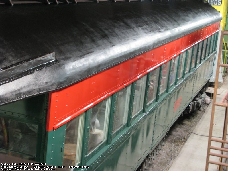 An elevated view showing the left side of the car, with fresh paint on the sides and roof.