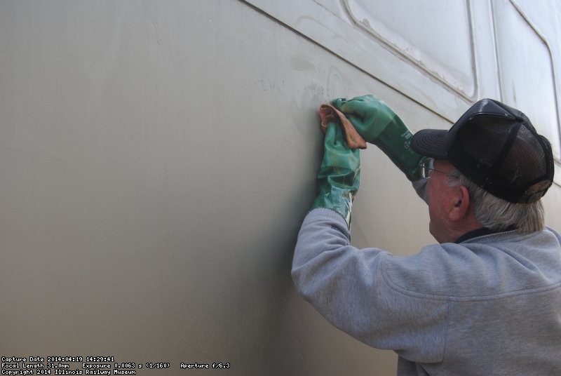 Kevin Kriebs removing adhesive on 1st Exhibit Car exterior