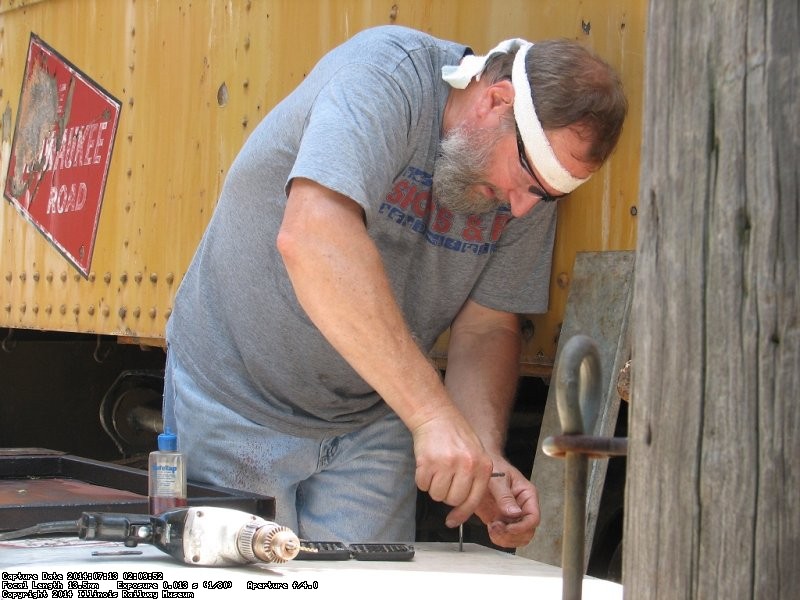 Chuck drilling and tapping holes for the new door face - Photo by Pauline Trabert