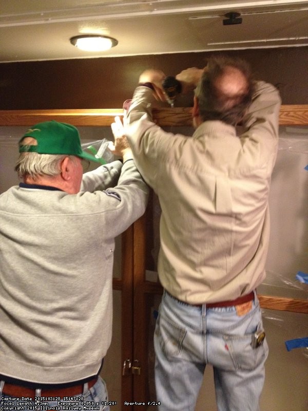 Buzz and Kevin attaching the cabinet to the wall in Exhibit Car 1 - Photo by Michael McCraren 