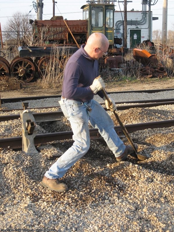 Frank loosening ballast around the tie to be removed