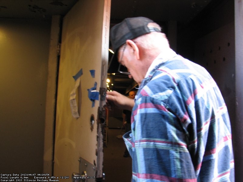 Wayne Baksic fixing a door lock in the 2nd Exhibit car.