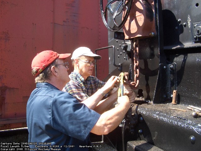 06.18.08 - VICTOR HUMPHREYS AND JOHN  FAULHABER INSTALL THE RIVET AND COTTER PIN SECURING THE CHAIN TO THE HANDBRAKE ROD.