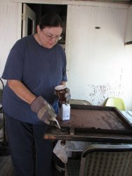Pauline Trabert applies rust converter to Dyno door - Photo by Shelly Vanderschaegen