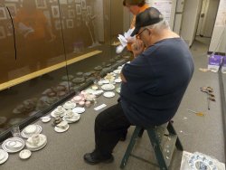 Michael McCraren and Mark Gellman work on the china display - Photo by Brian LaKemper