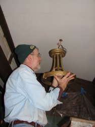 Here Buzz is mounting the refinished light fixture to the newly refinished ceiling. 