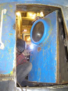 Jamie Kolanowski works on welding in the new nose door hardware