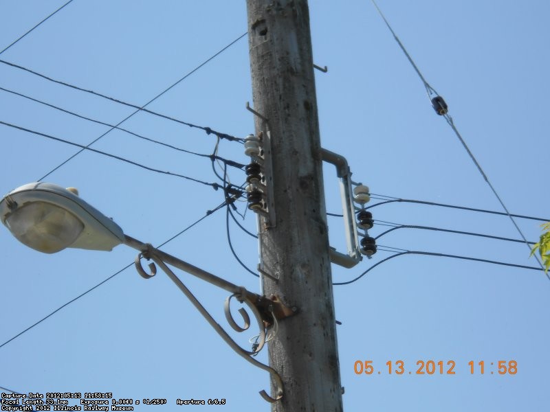 service drop to Schroder store. connections at pole.  Note white insulator on neutral.  Brown insulators on phase wires.