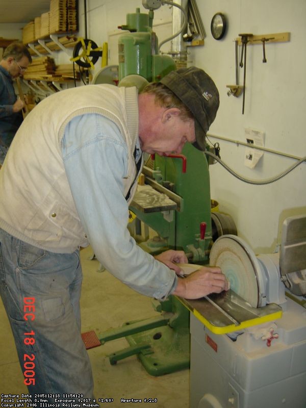 12.18.05 - BOB KUTELLA IS SANDING ONE OF THE RETAINING ARC SEGMENTS SO THAT IT FITS INSIDE OF THE STEEL RIM.