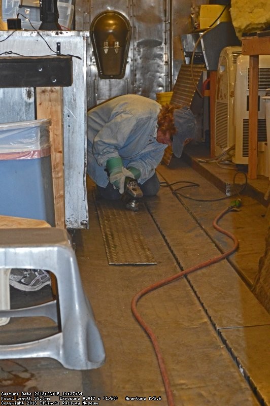 Shelly Vanderschaegen wire wheeling the last piece of the flooring to place