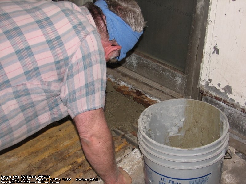 Working the concrete between the steel and wood to make it more supportive. 