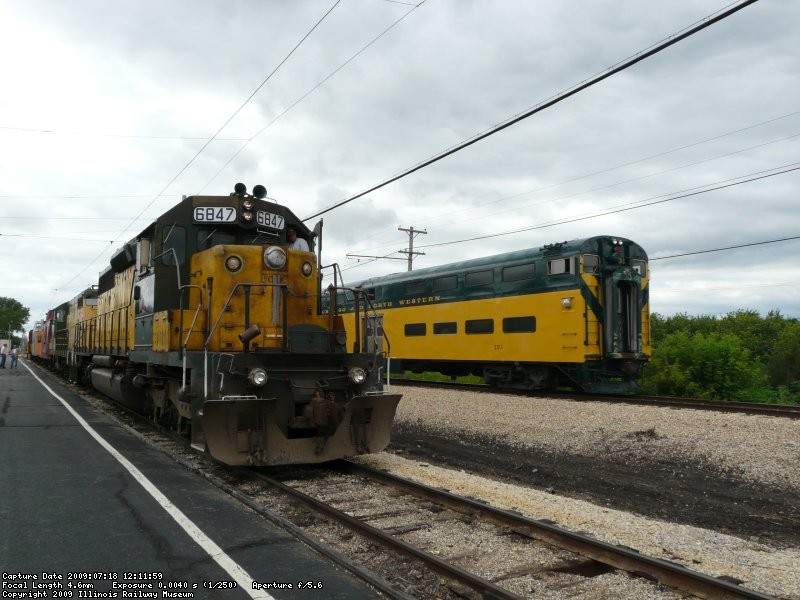 CNW 6847 awaits its departure on its first day in revenue service as CNW 151 passes by. 7/18/09