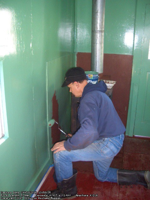 12.16.07 - VICTOR HUMPHREYS IS PAINTING THE HEAT SHIELD BEHIND THE FUEL OIL STOVE.