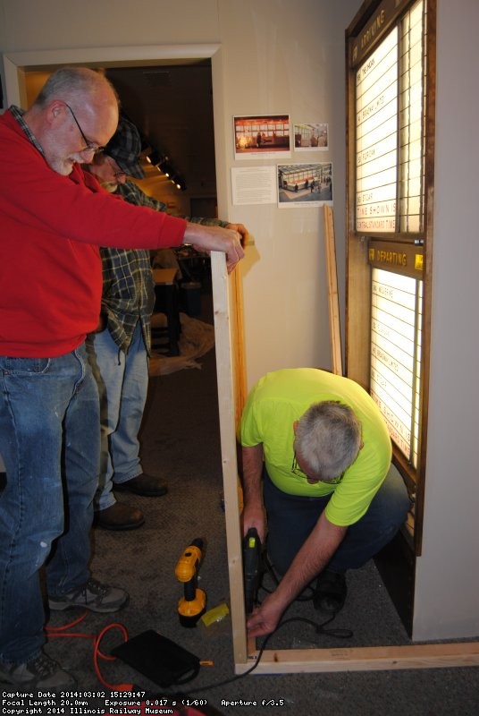 Mike and Jon hold the plexiglass while Mark secures the frame