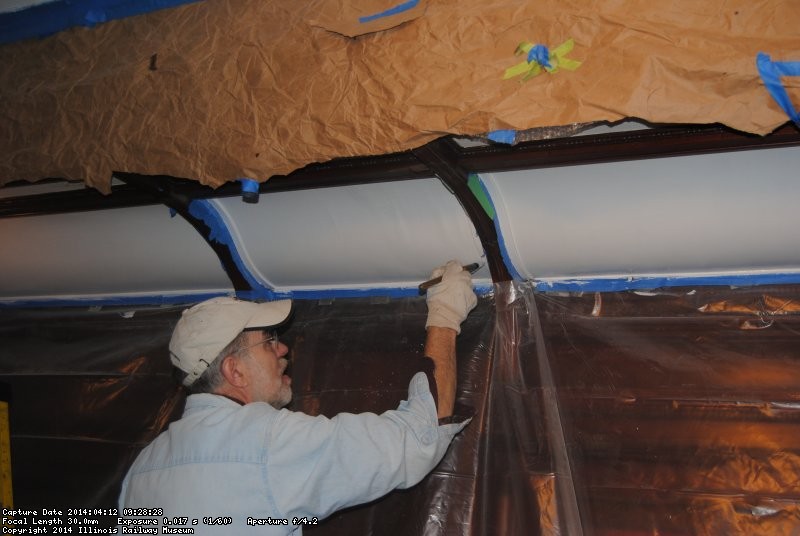 Buzz Morisette painting the rounded ceiling in the Ely dining room