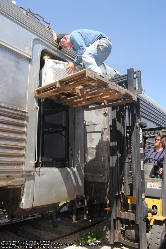 Curator Michael Baksic rode the fork lift up with the AC unit for installation - Photo by Shelly Vanderschaegen