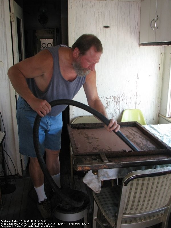 Chuck Trabert vacs loose rust from Dynamometer door frame - Photo by Pauline Trabert