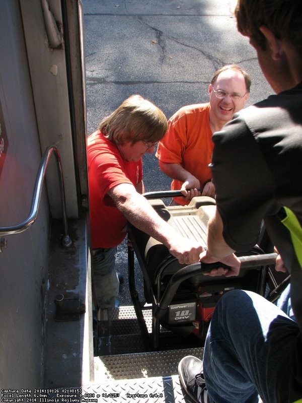 Mark Gellman, Warren Newhauser and his helper Fred lift a faulty generator from the vestibule for repair - Photo by Pauline Trabert