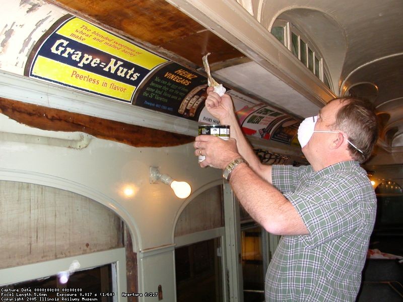 Randy Hicks applies contact cement to ceiling panels before installing new veneer 20 November 2004