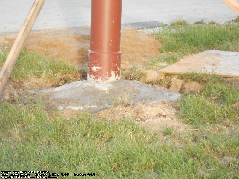 Steel pole set in concrete.