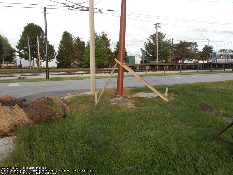 Newly installed steel strain pole.  Wood bracing steadies pole while concrete sets.