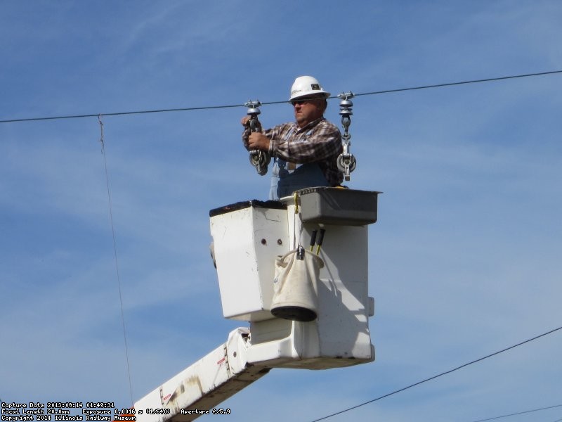 Installing conductor stringing blocks.  These will be used to pull-in and sag the new trolley wire.