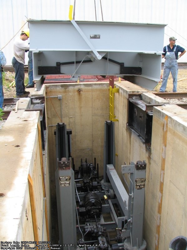 Positioned over the pit, the table is steadied for lowering. (Stuart B. Brosh photo)