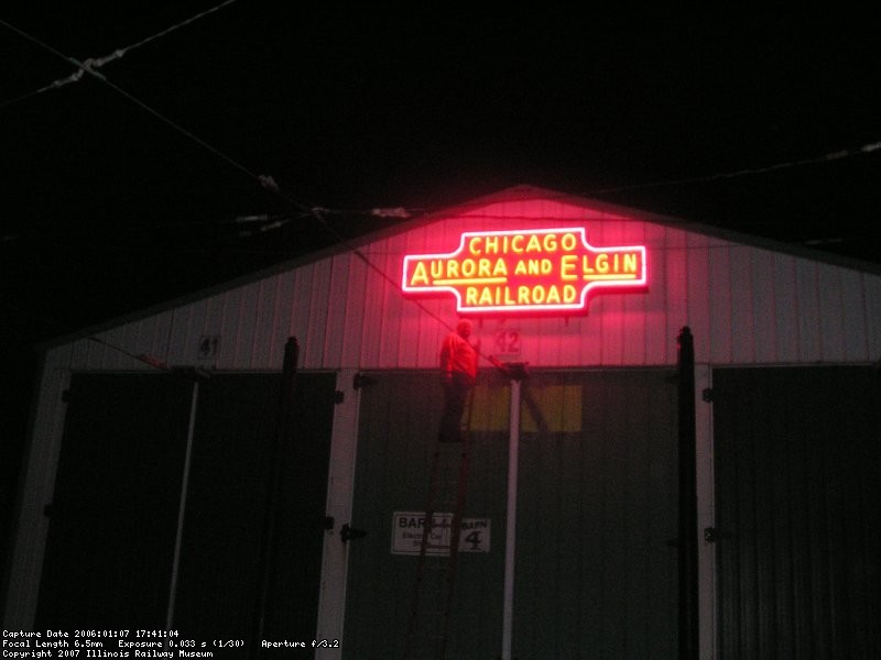 Max Tymns poses next to the sign after it is lit.
