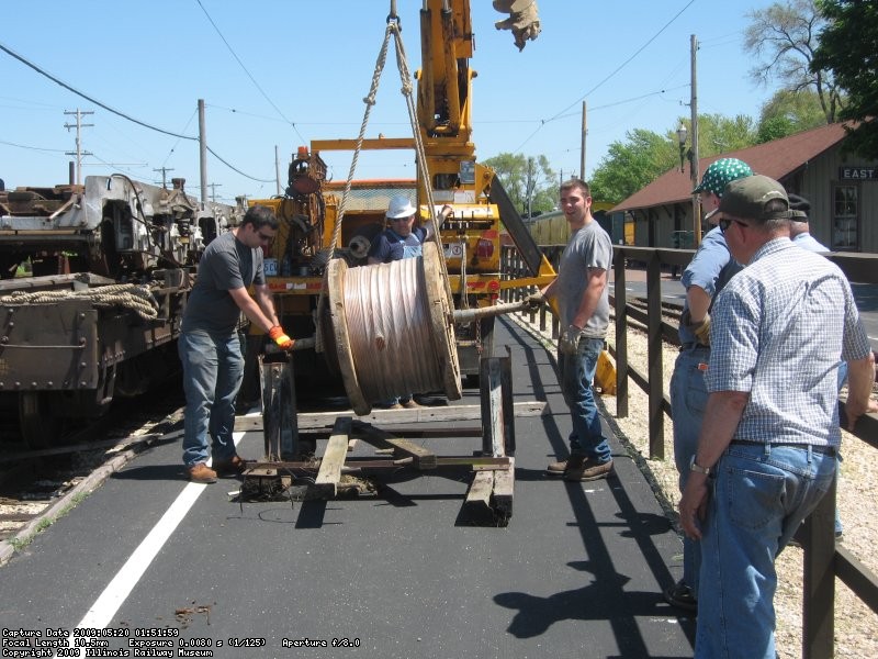 Placing the new wire in position to begin feeding it through the hangers