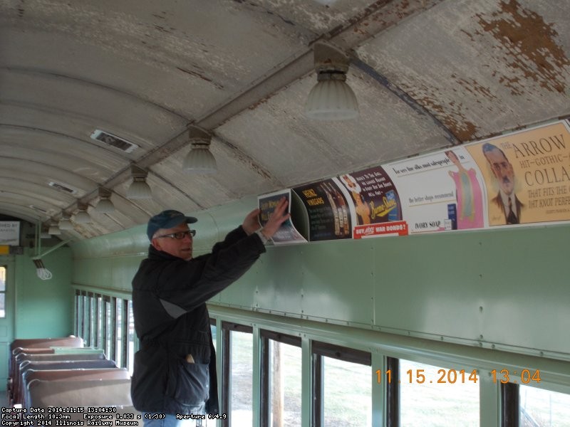 Here's Rick starting to install advertising reproduction car cards  in the RI 2602    You have got to be hearty and devoted to come out on cold days like this.  Its 22degrees No heat in this car but the job gets done.    11-15-14   DSCN1178