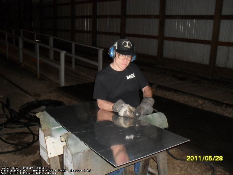 Andy Townsend cutting  Aluminum sheet for future repair of round window in womens washroom. IC 3345 May 2011