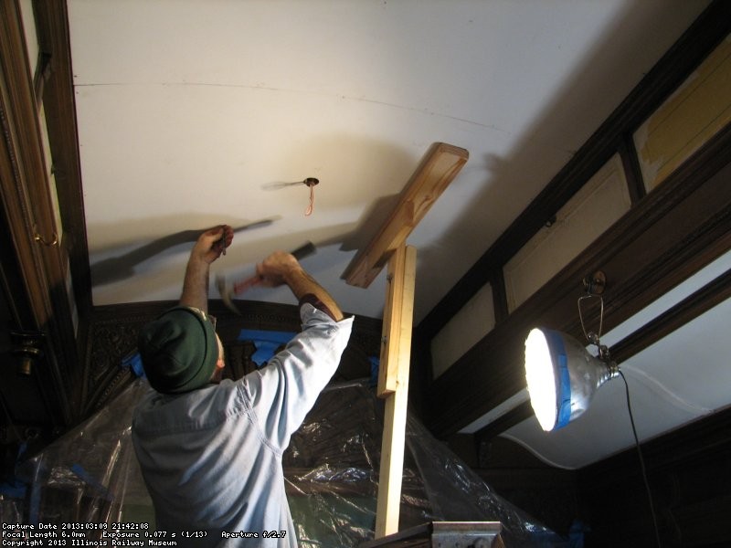 Buzz Morrisette setting a nail in the ceiling. 