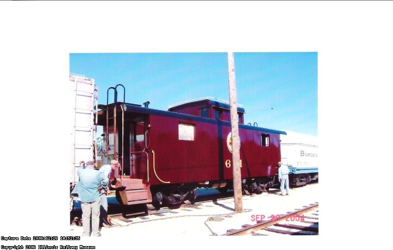 09.19.04 - BOB KUTELLA IS NEEDLE CHIPPING ON THE A END OF THE CAR WHILE JOHN NELIGAN OBSERVES.  VICTOR HUMPHREYS WIRE WHEELS PART OF THE B END OF THE CAR.  THE HERALD HAS NOW BEEN APPLIED WITH STAINLESS STEEL STUDS AND NUTS.  THE NEW CUPOLA WINDOWS HAVE BEEN APPLIED.
