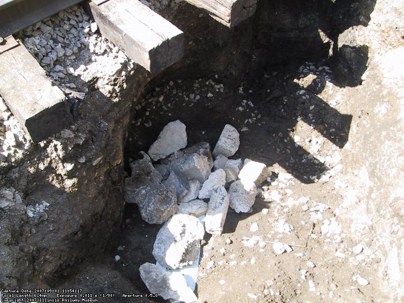 As a temporary repair, we place some large aluminum plates around the breach, and a smaller one over the top of the two sections.  Then placed some large stone and concrete chunks on top.