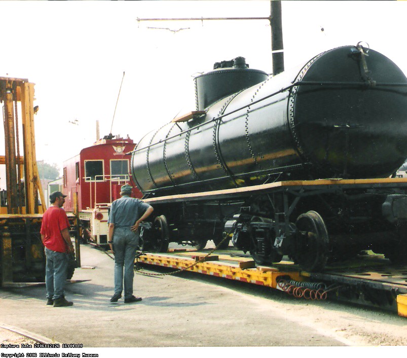 THE CAR IS SLOWLY MOVED OFF OF THE TRAILER WITH THE CORNWALL ENGINE BEING USED TO STOP THE CAR IF IT MOVES TOO QUICKLY.  BOB KUTELLA AND JEFF DELLHAYE OBSERVE IWTH INTEREST.