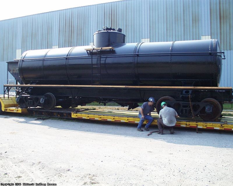 THE CAR HAS BEEN LOADED ONTO SILK ROAD TRANSPORT'S TRAILER BY PUSHING IT UP A RAMP THAT ATTACHES TO THE TRAILER.