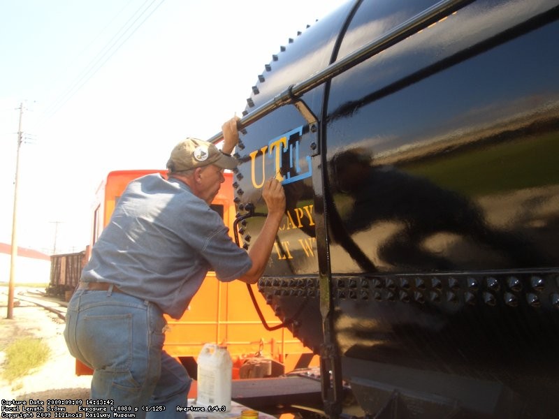 09.09.09 - BOB IS PAINTING ON THE LETTERS FORMED BY THE STENCIL.  THE YELLOW COLOR TAKES TWO COATS TO COVER THE BLACK PAINT, WHICH INCREASES THE TIME TO LETTER DRAMATICALLY.