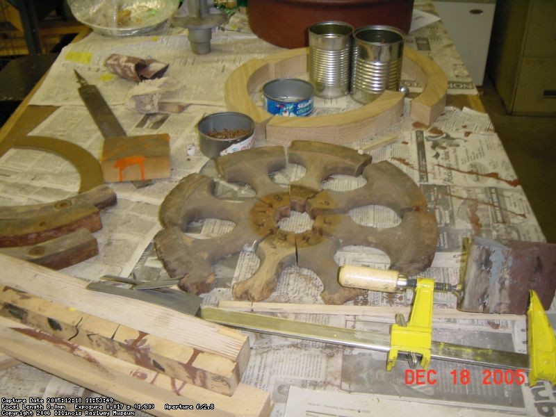 12.18.05 - THESE ARE THE INNER SPOKES OF THE WHEEL WHICH WERE ROTTED AND HAD TO BE DUPLICATED.  THEY GO INSIDE OF THE STEEL RIM.  IN THE REAR OF THE PHOTOS ARE FOUR OF THE ARC SEGMENTS WHICH HOLD THE SPOKES IN PLACE IN THE RIM.