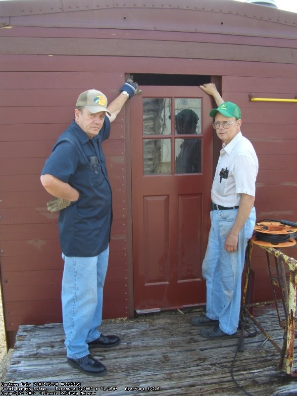 05.30.07 - JOHN FAULHABER AND VICTOR HUMPHREYS HOLD ONE OF THE NEW DOORS TO CHECK THE FIT OF THE DOORFRAME WHICH IS BEING INSTALLED.