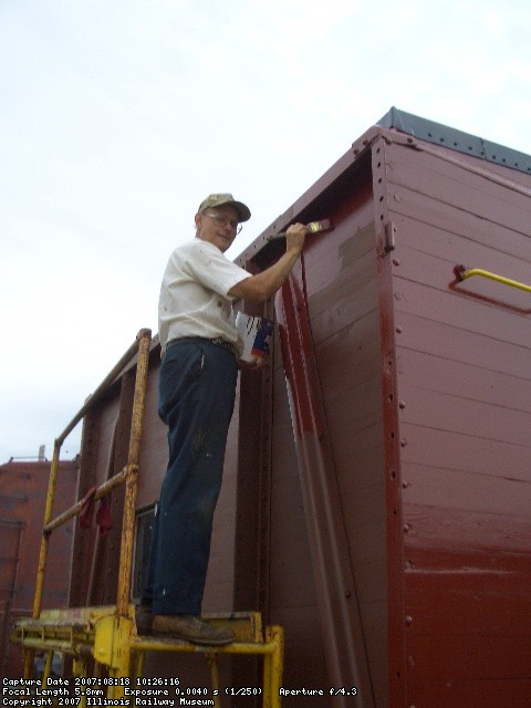 08.18.07 - VIICTOR HUMPHREYS HAS PAINTED THE A END OF THE CABOOSE AND IS NOW APPLYING FINISH PAINT TO THE RIGHT SIDE OF THE CABOOSE.