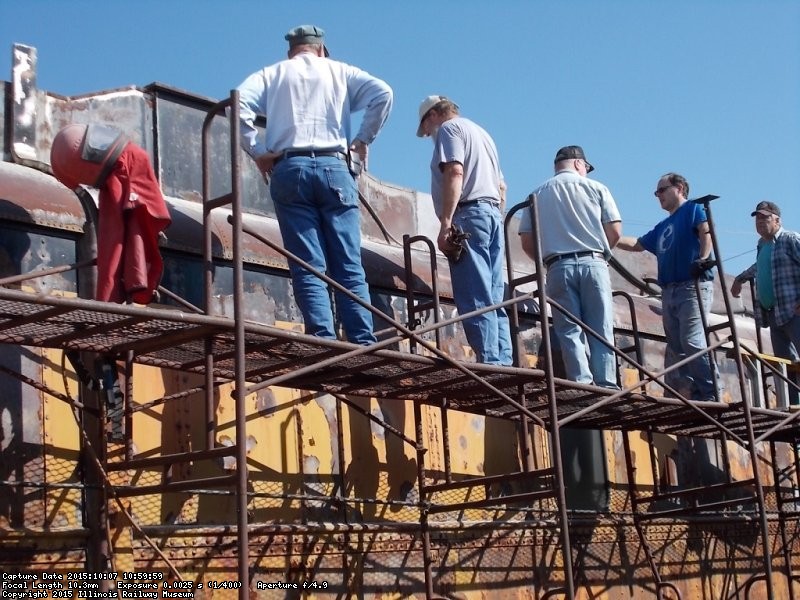 The team gathered on the scaffold to examine the early sandblasting results - Photo by Jane Pomazal