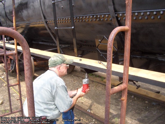 07.27.08 - RAY MORANN IS DRILLING HOLES TO APPLY TIMBER BOLTS TO HOLD THE RUNNING BOARD IN PLACE.