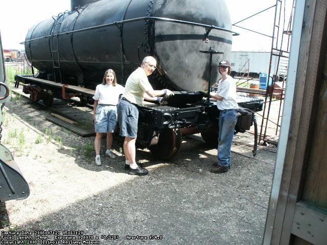 07.26.08 - THE STARR FAMILY, FROM THE LEFT, MARILYNN, TOM AND ERIC, IS STAINING THE UNDERSIDE, ENDS AND EDGES OF THE RUNNING BOARDS PRIOR TO THEIR BEING ATTACHED TO THE CAR.