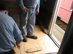 The first piece of plywood in place over the concrete by the door.