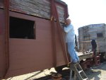 06.13.07 - KIRK WARNER IS TIGHTENING THE BOLTS ON THE LAST ROW OF SIDING TO BE APPLIED FOR THE DAY.  VICTOR HUMPHREYS, HAND OUTSTRETCHED, HAS JUST HANDED OUT THE LAST NUT.