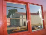 09.09.07 - KIRK WARNER HAS MADE THE PIECES TO HOLD THE RIGHT WINDOW PANE IN PLACE.  THE WINDOW GLASS IS NOW GASKETED, SECURED AND THE FRAME IS PAINTED, WITH A FIRST COAT OF FINISH PAINT, TO COMPLETE THE EXTERIOR OF THE RIGHT SIDE WINDOW.