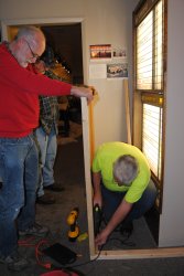 Mike and Jon hold the plexiglass while Mark secures the frame